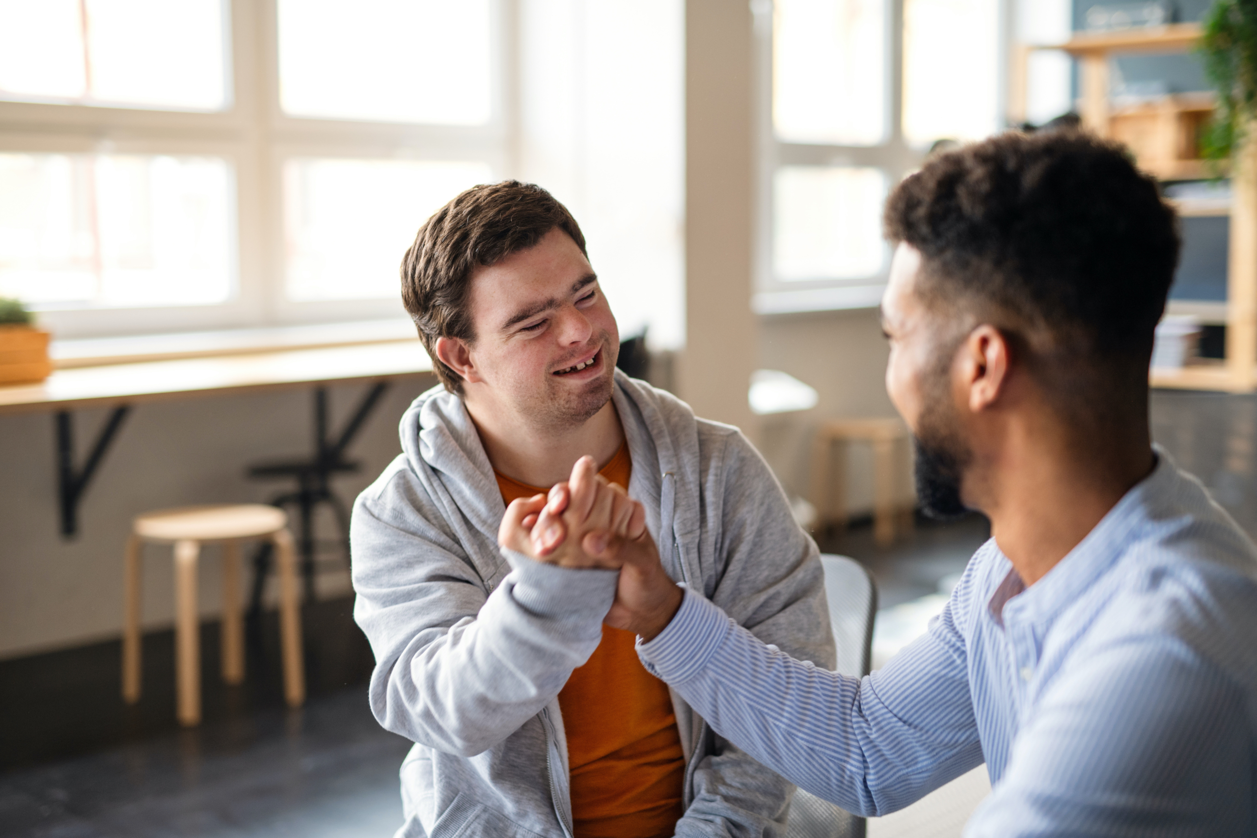 A young happy man with Down syndrome with his mentoring friend
