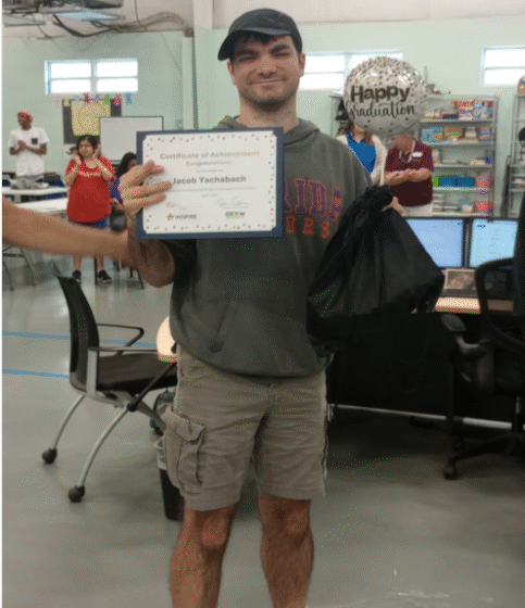 person with IDD holding graduation certificate